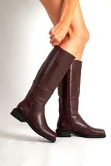 Botas de cuero de caña alta, con punta cuadrada y taco bajo. Disponibles en color bordó y negro.