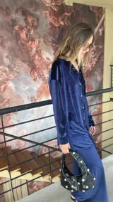 Camisa azul de terciopelo, corte oversize, con cuello camisero, manga larga y cierre frontal con botones.
