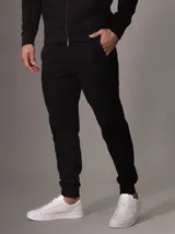Pantalón de jogging negro Calvin Klein, de corte ajustado, con cintura elástica con cordones, puños acanalados, bolsillos laterales con cremallera y logo distintivo de la marca.