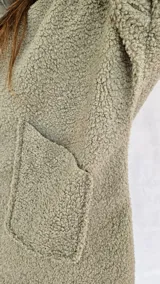 Campera color ocre con capucha y cierre frontal asimétrico.