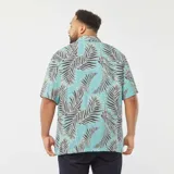 Camisa celeste con estampado de hojas de palmera en tonos negro y blanco, de corte holgado y manga corta.