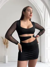 Minivestido negro con escote cuadrado, mangas largas de tul y aberturas en la cintura unidas por aros metálicos.