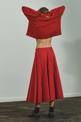 Falda midi roja de tiro medio con pliegues y cierre lateral con cremallera oculta.