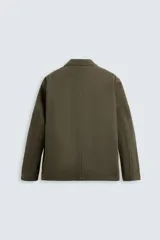 Blazer color verde militar de algodón con efecto lavado, corte relaxed fit, cuello con solapas de muesca, manga larga, bolsillos frontales de plastrón y cierre frontal con botonadura.