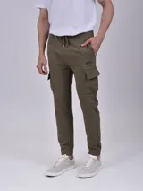 Pantalón de jogging verde militar con bolsillos cargo laterales, cintura ajustable con cordón y puños elásticos.