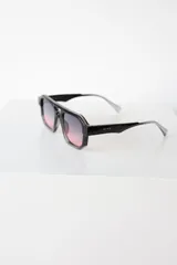 Lentes de sol de mujer con armazón grueso de policarbonato color rosa translúcido y lentes oscuros degradados. Diseño de montura geométrica con puente doble.