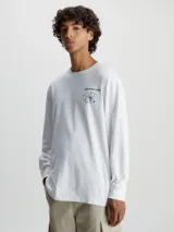 Remera blanca de manga larga Calvin Klein Jeans, confeccionada en algodón orgánico. Presenta cuello redondo, puños de canalé y un estampado con el logo de la marca en el pecho.