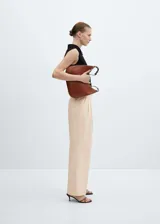 Pantalón de vestir color beige, de corte palazzo, con cinturón con hebilla forrada y cierre frontal oculto.