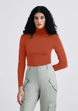 Blusa de tejido de punto color ladrillo, con cuello alto y mangas largas.