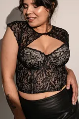 Corset negro con copas y aro, ballenas en la parte delantera, confeccionado en puntilla elastizada y microtul. Detalle de broche en el escote.