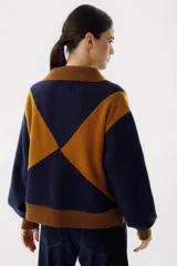 Campera bomber azul con diseño geométrico en color mostaza, cierre frontal y bolsillos laterales.