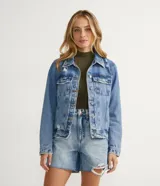 Campera de jean celeste con cuello camisero, cierre frontal con botones, bolsillos delanteros y recortes.