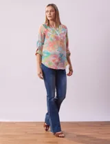 Blusa de gasa estampada con rayas verticales en tonos celeste, azul y blanco. Tiene cuello a la base con escote en V y abertura con botones. Las mangas largas son de largo regulable.