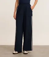 Pantalón deportivo azul marino de corte ancho, con cintura elástica, bolsillos laterales y dos rayas verticales blancas a lo largo de cada pierna.