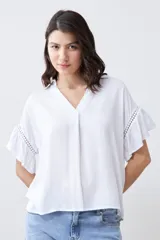 Blusa blanca con escote en V y mangas cortas con volados.