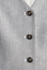 Chaleco de vestir con escote en V, botonadura frontal y trabilla ajustable en la espalda. Diseño a rayas verticales en tonos gris y blanco. Forrado.