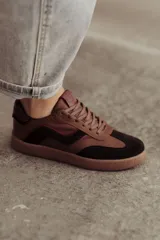 Zapatillas bajas de cuero color marrón con suela de goma color caramelo y cordones marrones.