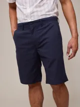 Bermuda de vestir azul marino, con bolsillos laterales y traseros.