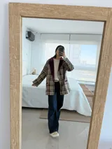 Blazer marrón con estampado escocés, solapas con borde de terciopelo marrón oscuro y corte recto.