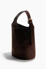 Bolso tipo bombonera de color marrón oscuro, con textura de gamuza o nobuck. Posee un asa de hombro ancha y ajustable con hebilla metálica dorada.