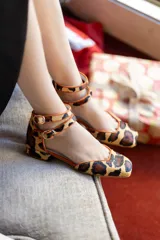 Bailarinas de tacón bajo (2,5 cm) con estampado animal print y ribete naranja. Interior de piel y suela de cuero.