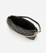 Bolso baguette pequeño color crema, confeccionado en cuero sintético con textura matelaseada en forma de rombos. Presenta correa corta al hombro y detalle de cadena dorada en el frente.