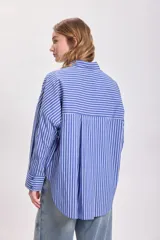 Camisa celeste con rayas verticales blancas, de corte holgado y mangas largas.