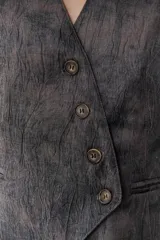 Chaleco grafito con cuello en V, cierre frontal con botones y bolsillos ribeteados.