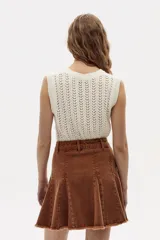 Minifalda acampanada de denim color caramelo con cintura alta y ruedo desflecado.