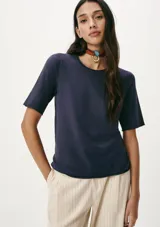 Blusa azul de tejido de punto con mangas cortas y cuello redondo.