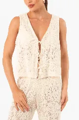 Chaleco de punto color crudo, con escote en V, abertura frontal y cierre con cordones.