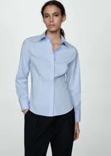 Camisa blanca entallada de popelina de algodón con cuello camisero, cierre frontal con botones y mangas largas con puños abotonados.