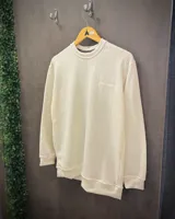 Buzo blanco de punto con cuello redondo y bordado blanco sobre blanco.
