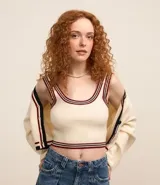 Musculosa de punto color crema con textura acanalada, escote redondo, breteles medianos y detalles contrastantes en bordó y negro en cuello, sisas y ruedo.