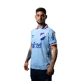 Camiseta de fútbol Umbro del Club Nacional de Football, modelo Away 3 temporada 2025. Diseño celeste con detalles en blanco, azul y rojo en cuello y mangas. Incluye logo de Umbro, escudo del club y sponsor Antel en el frente.