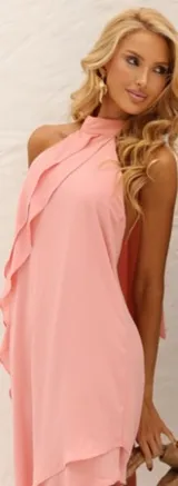 Vestido color rosa con escote halter, corte asimétrico y volados en el frente.