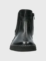 Botín Chelsea de cuero negro, estilo botineta, con elástico lateral y suela gruesa con costura visible en el borde.