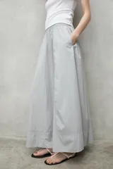 Falda larga gris con cintura elástica y bolsillos laterales.