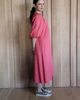 Vestido midi celeste de denim, con escote con lazo, mangas 3/4 abullonadas y corte evasé.