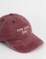 Gorra de denim color borgoña con bordado frontal que dice "New York 1990" en blanco.