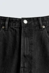 Pantalón de jeans de algodón, corte baggy fit, tiro medio, con efecto lavado en tonos grises y verdes. Presenta cinco bolsillos y cierre frontal con cremallera y botón.