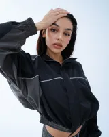 Campera deportiva bomber negra con recortes y vivos blancos.