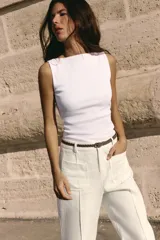 Camiseta sin mangas a rayas horizontales blancas y negras, con cuello barco y corte ajustado.