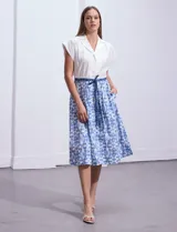 Vestido midi de algodón, marca Sandra Darren. Presenta escote solapado, cierre frontal con botones, manga corta, cintura elastizada con pasadores y lazo de ajuste.