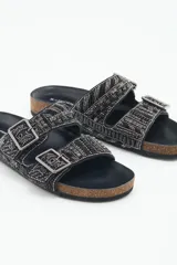 Sandalia baja abierta de cuero con bordado de mostacillas, canutillos y strass en toda la parte exterior. Plantilla de corcho a la vista forrada con cuero y fondo de goma. Hebillas metálicas color peltre.