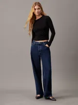 Remera negra de punto modal elástico, con cuello redondo, mangas largas y detalle plisado en un lateral.