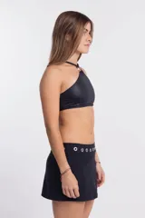 Top de bikini negro con corte halter y detalle de aro metálico en el cuello.