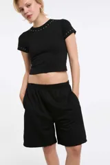 Short deportivo negro con cintura elástica y bolsillos laterales. Corte holgado a la rodilla.