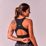 Top deportivo negro con breteles anchos y espalda deportiva.
