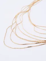 Collar dorado con múltiples cadenas finas dispuestas en cascada.